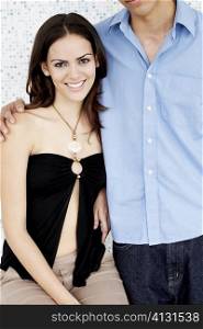 Portrait of a young woman smiling with a young man standing beside her