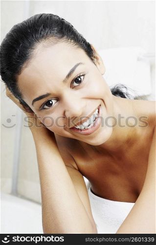 Portrait of a young woman smiling with her hand in her hair
