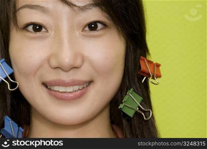 Portrait of a young woman smiling with paper clips in her hair
