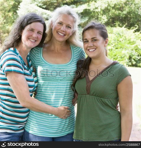 Portrait of a young woman smiling with two mature women