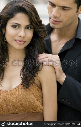 Portrait of a young woman smirking with a mid adult man standing behind her