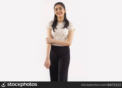 Portrait of a young woman standing against plain background.