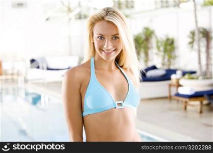 Portrait of a young woman standing at the poolside