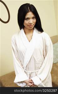 Portrait of a young woman standing in a bathrobe