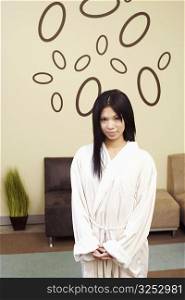 Portrait of a young woman standing in a bathrobe