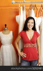 Portrait of a young woman standing in a clothing store