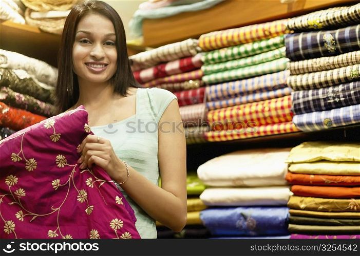 Portrait of a young woman standing in a clothing store