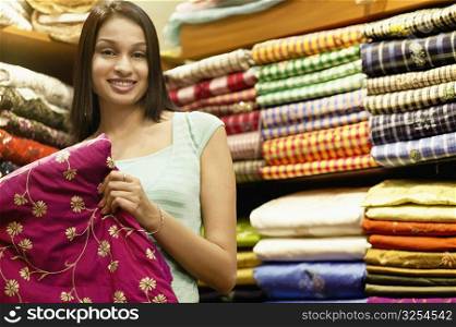Portrait of a young woman standing in a clothing store