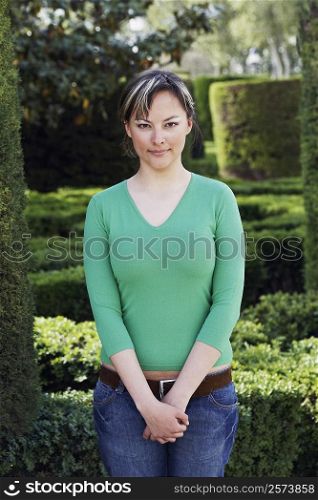 Portrait of a young woman standing in a garden