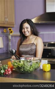 Portrait of a young woman standing in the kitchen smiling