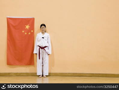 Portrait of a young woman standing near a Chinese flag
