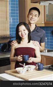 Portrait of a young woman standing with a young man holding a tea cup