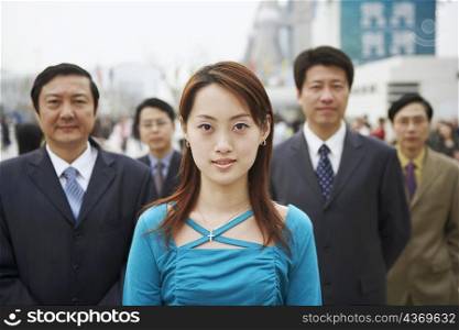 Portrait of a young woman standing with four businessmen