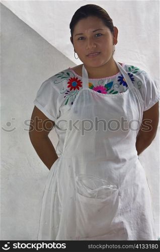 Portrait of a young woman standing with her hands behind her back, Papantla, Veracruz, Mexico