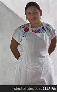 Portrait of a young woman standing with her hands behind her back, Papantla, Veracruz, Mexico