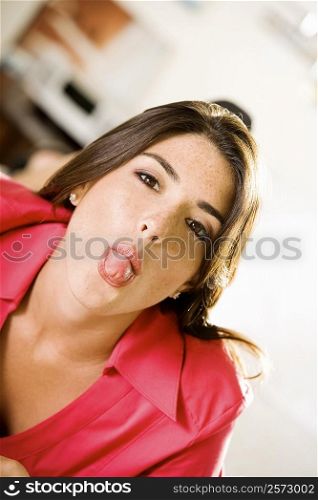 Portrait of a young woman sticking out her tongue