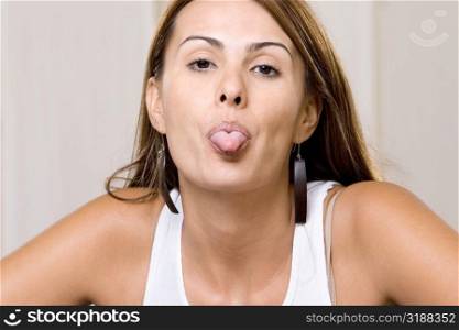 Portrait of a young woman sticking out her tongue