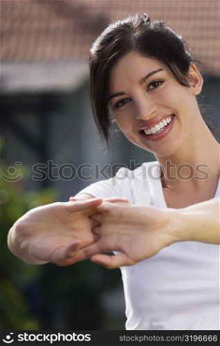 Portrait of a young woman stretching her hands and smiling