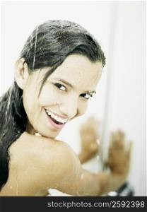 Portrait of a young woman taking a shower and smiling