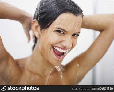 Portrait of a young woman taking a shower and smiling