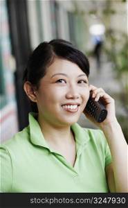 Portrait of a young woman talking on a cordless phone