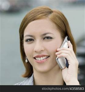 Portrait of a young woman talking on a mobile phone and smiling