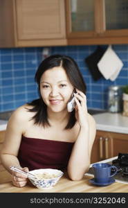 Portrait of a young woman talking on a mobile phone smiling