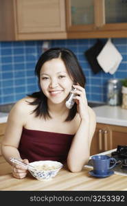 Portrait of a young woman talking on a mobile phone smiling