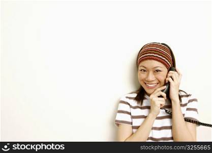 Portrait of a young woman talking on the telephone and smiling