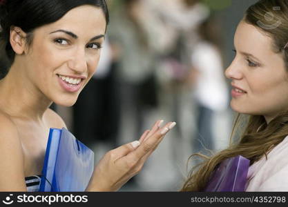 Portrait of a young woman talking to her friend and smiling