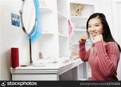 Portrait of a young woman trying on a necklace in a store