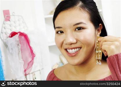 Portrait of a young woman trying on an earring in a store
