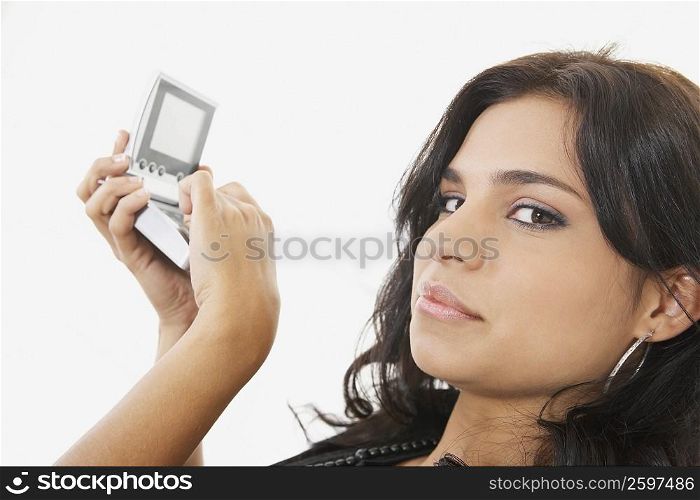 Portrait of a young woman using a calculator