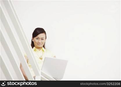 Portrait of a young woman using a laptop and smiling