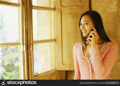 Portrait of a young woman using a mobile phone and smiling