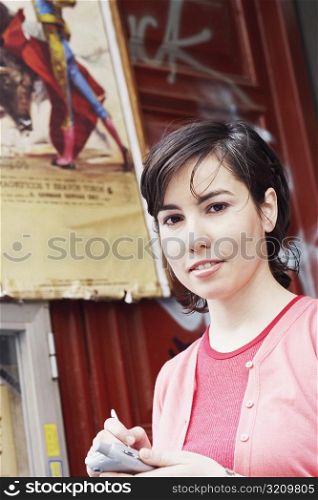 Portrait of a young woman using a personal data assistant