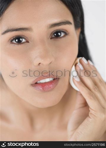 Portrait of a young woman using a powder puff
