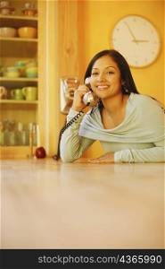 Portrait of a young woman using a telephone and smiling