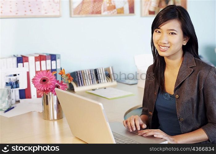 Portrait of a young woman using laptops