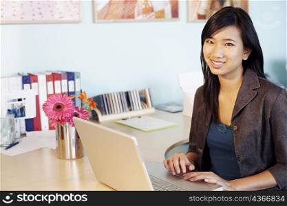 Portrait of a young woman using laptops