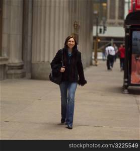 Portrait of a young woman walking on the side walk