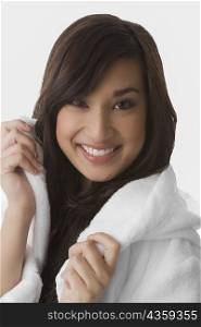 Portrait of a young woman wearing a bathrobe and smiling