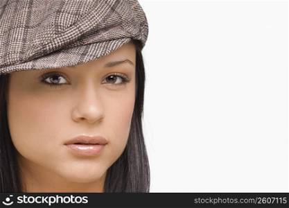 Portrait of a young woman wearing a flat cap
