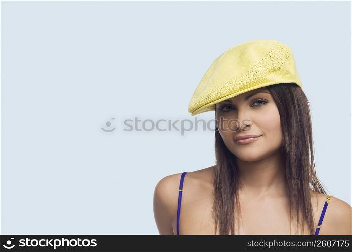 Portrait of a young woman wearing a flat cap and smirking