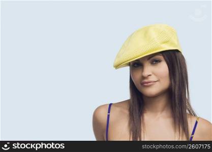 Portrait of a young woman wearing a flat cap and smirking
