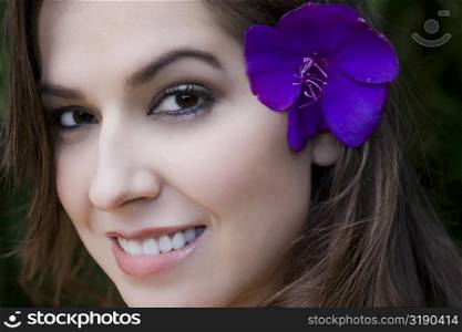 Portrait of a young woman wearing a flower and smiling