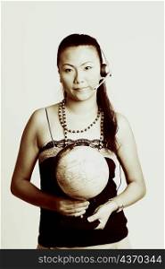 Portrait of a young woman wearing a headset and holding a globe
