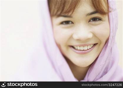 Portrait of a young woman wearing a scarf smiling