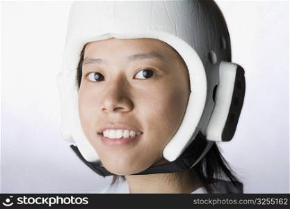 Portrait of a young woman wearing a sports helmet and smiling