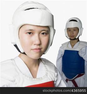 Portrait of a young woman wearing a sports helmet with another young woman standing in the background